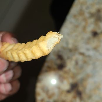 Raising Cane's Chicken Fingers - a person holding a piece of chicken - Fast Food Near Me - Houston, Texas