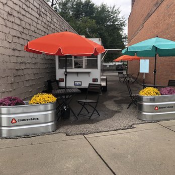 Tin Can Cafe - two tables with umbrellas - Food Trucks Near Me - Ferndale, Michigan