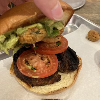 Evolve kitchen - a person grabbing a hamburger from a tray - Salad Near Me - Clemson, South Carolina
