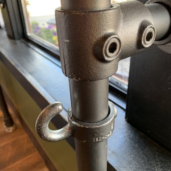 Scratch Baking - Fun hat hooks on the bar seating overlooking the town green... - Bakeries Near Me - Milford, Connecticut