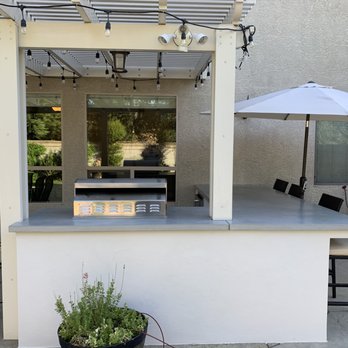 Conner Plastering - an outdoor kitchen with a table and chairs - General Contractors Near Me
