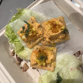 The Red Fork - Happy Campers - Three crackers topped with a creamy mixture, garnished with herbs and chopped vegetables, served on lettuce leaves with a light-colored tray. - Salad Near Me - Erwin, Tennessee