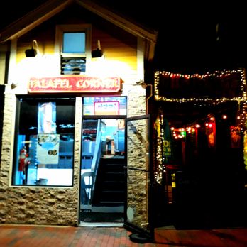 Falafel Corner - Outside the tiny kiosk-sized shop. - Nighttime exterior of Falafel Corner, a Middle Eastern takeout spot, with lit signage and decorative string lights. - Middle Eastern Near Me - Cambridge, Massachusetts