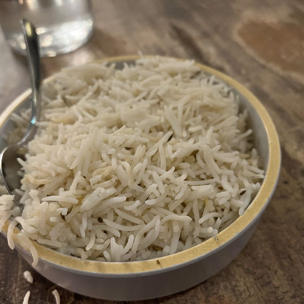 a bowl of rice and a spoon on a table
