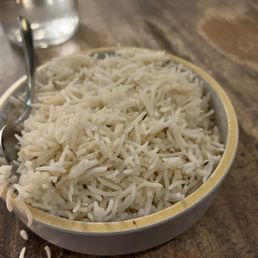 a bowl of rice and a spoon on a table