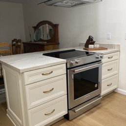 a kitchen with a stove and island a kitchen with a stove and island