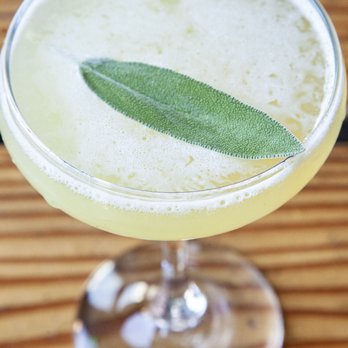 Corner Social - a glass of a drink with a sage leaf on the rim - New American Near Me - New York, New York Corner Social - a glass of a drink with a sage leaf on the rim - New American Near Me - New York, New York
