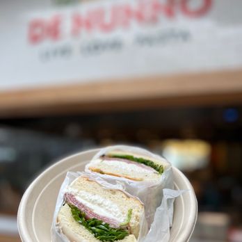 De Nunno - a person holding a plate with a sandwich on it - Italian Near Me - San Diego, California De Nunno - a person holding a plate with a sandwich on it - Italian Near Me - San Diego, California