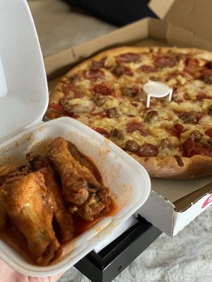 Photo of Falcone's Pizza - Pico Rivera, CA, US. a hand holding a box of wings and a pizza
