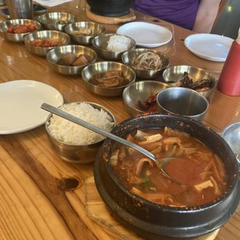 Korea House - Kimchi Jjigae surrounded by Banchan side dishes - Korean Near Me - Austin, Texas Korea House - Kimchi Jjigae surrounded by Banchan side dishes - Korean Near Me - Austin, Texas