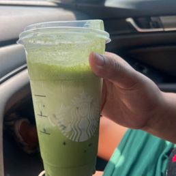 a person holding a cup of green tea a person holding a cup of green tea