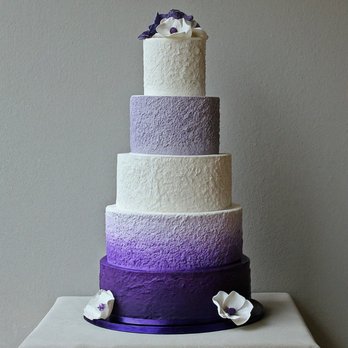 Cake Frosted - a three tiered cake with purple and white frosting - Cupcakes Near Me