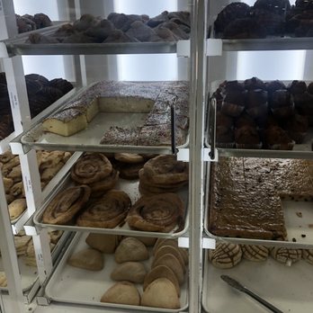 El Super - Pan Dulce - A bakery display case contains an assortment of baked goods such as cinnamon rolls, cookies, and cake slices, with some items partially eaten. - Grocery Near Me - El Paso, Texas
