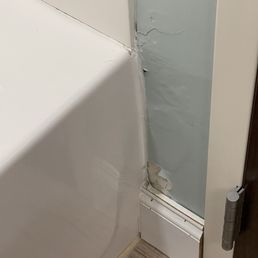 Warped wall with peeling paint in the bathroom