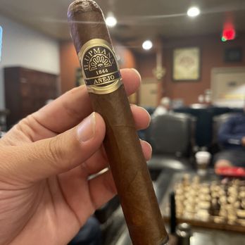 Cigar Town and Lounge - a hand holding a cigar - Tobacco Shops Near Me - Herndon, Virginia