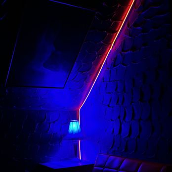 Mad Planet - a dark room with a couch and a lamp - Dance Clubs Near Me - Milwaukee, Wisconsin