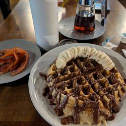Grinds Cafe and Sweet Shoppe - Belgium Waffle with Nutella and sliced banana with a side of bacon
