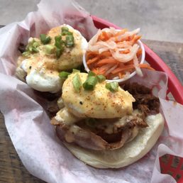 Bacon Egg's Benedict, served on a bao muffin, topped with kimchi hollandaise, togarashi flakes, and some green onions.
