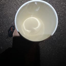 Vanilla Latte - A person holds a cup of vanilla latte, viewed from above, with a dark ground background.