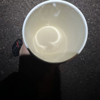 The Perkatory - Vanilla Latte - A person holds a cup of vanilla latte, viewed from above, with a dark ground background. - Desserts Near Me - Snowflake, Arizona