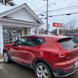 a red suv parked in front of a building
