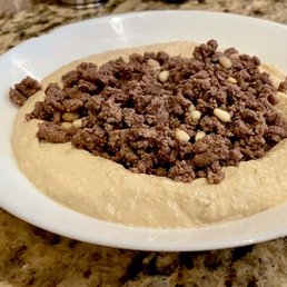 Hummus Ma Lahme - Pasture Raised minced beef, roasted with coconut oil and pine nuts, served on top of a bowl of hummus.