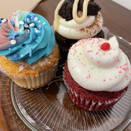 three cupcakes on a glass plate three cupcakes on a glass plate