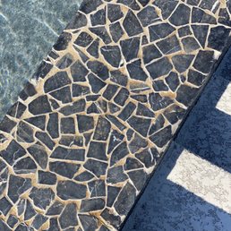 a closeup of a pool with a stone floor