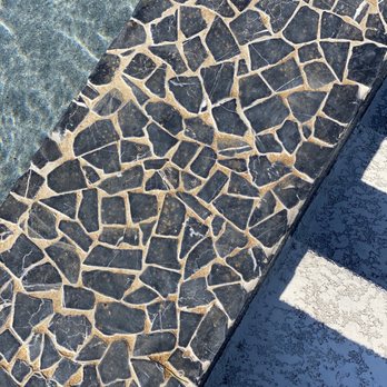 TexasTurf - a closeup of a pool with a stone floor - Landscaping Near Me - Lakeway, Texas