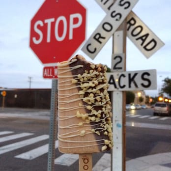Popbar - Hazelnut half dipped in milk chocolate with white chocolate drizzled and almonds to make life interesting. - Desserts Near Me - Anaheim, California
