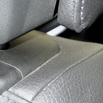 Ceramic Garage - A detailed view of a vehicle's interior focusing on the back of a seat and the seat cushion, both covered in gray leather or vinyl material. - Car Window Tinting Near Me - Modesto, California