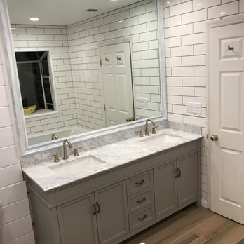 CMF Contracting - a bathroom with two sinks and a large mirror - General Contractors Near Me CMF Contracting - a bathroom with two sinks and a large mirror - General Contractors Near Me