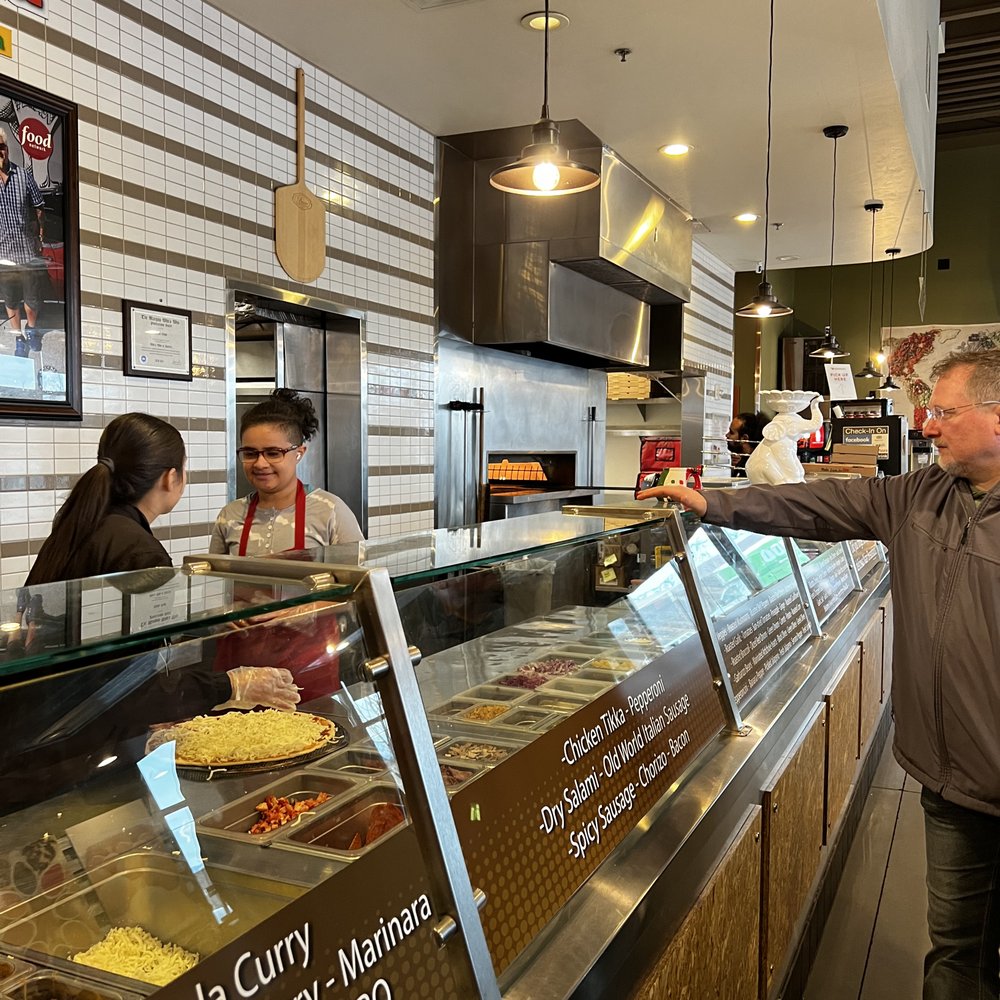 Curry Pizza - a man serving customers in a restaurant - Pizza Near Me - West Valley City, Utah Curry Pizza - a man serving customers in a restaurant - Pizza Near Me - West Valley City, Utah