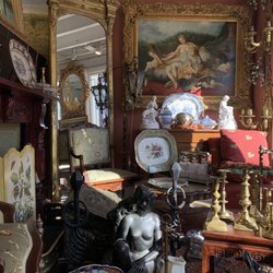 A Galerie - Entryway of A Galerie, with art, furniture, & mirrors on display.