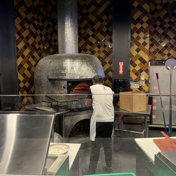 Pizza Rock - Preparing a pizza in the wood-fired oven. - Pizza Near Me - Henderson, Nevada Pizza Rock - Preparing a pizza in the wood-fired oven. - Pizza Near Me - Henderson, Nevada