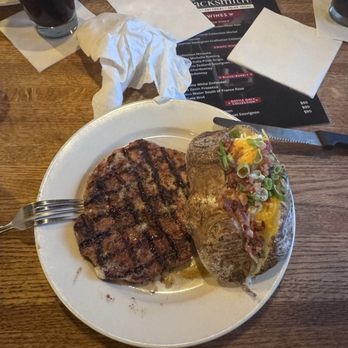 The Blacksmith Restaurant - Pork ribeye with loaded baked potato. - Bars Near Me - Dyersburg, Tennessee The Blacksmith Restaurant - Pork ribeye with loaded baked potato. - Bars Near Me - Dyersburg, Tennessee