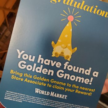 World Market - a person holding a sign that says you have found a golden gnome - Furniture Stores Near Me - Bloomington, Minnesota