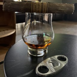 a glass of whiskey and a cigar cutter a glass of whiskey and a cigar cutter