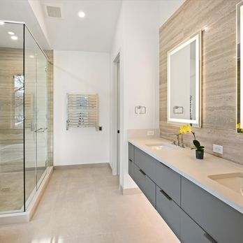 McSwain Builders - Luxurious bathroom featuring floating double vanity, elegant stone-look tile, frameless glass shower, and backlit mirrors that create a spa- - General Contractors Near Me - Glenwood Springs, Colorado McSwain Builders - Luxurious bathroom featuring floating double vanity, elegant stone-look tile, frameless glass shower, and backlit mirrors that create a spa- - General Contractors Near Me - Glenwood Springs, Colorado