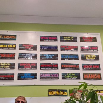 Daiquiri Shak - a man sitting at a table in front of a menu - Cocktail Bars Near Me - Bay Saint Louis, Mississippi