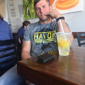 The Chopped Leaf - a man sitting at a table with a drink - Salad Near Me - Edmonton, Alberta