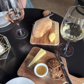 Bistro Vendôme - butter with flaky sea salt and bread next to a glass of rose and a sparkling white sheep milk cheese white grape jelly crackers - French Near Me - Denver, Colorado