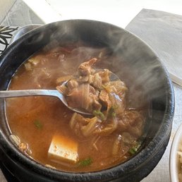 a bowl of soup with a spoon in it a bowl of soup with a spoon in it