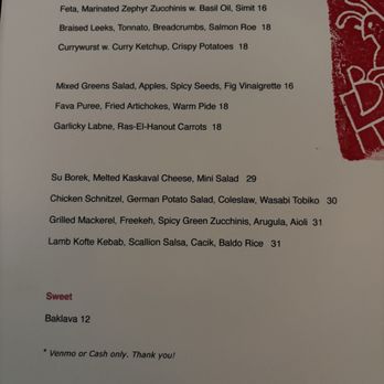 Bunny - Menu - A menu printed on white paper lists dishes such as cigars with spicy potatoes, marinated zucchini, braised leeks, and currywurst, along with salads and main courses like lamb kofte kebab and chicken schnitzel, with prices ranging from 12 to 31. A red logo or graphic is partially visible on the right side of the image. - Turkish Near Me - Brooklyn, New York