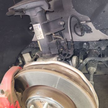 America's Tire - Front suspension with groove worn into the edge of strut and damage to brake rotor guard, due to incorrect installation. - Tires Near Me - Riverbank, California