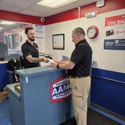 AAMCO Transmissions & Total Car Care - Our AAMCO Atlantic Blvd team assisting a customer at the front counter and keeping the repair process clear and straightforward.