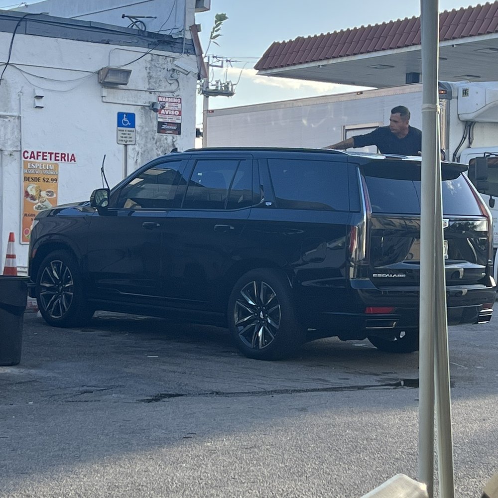a black van parked in front of a gas station a black van parked in front of a gas station