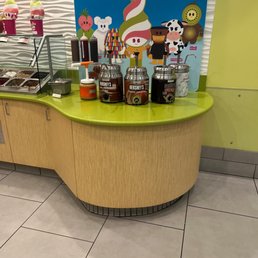 a counter with a variety of frozen yogurts a counter with a variety of frozen yogurts