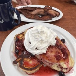 The Corner Cafe - Thick sliced bacon and a short stack with triple berries and fresh whipped cream.
