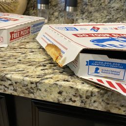 Piece of pizza stuck to outside of box. Piece of pizza stuck to outside of box.